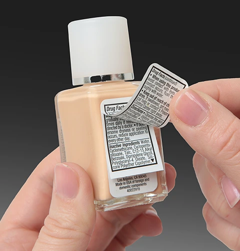 makeup product with a pressure sensitive extended content label being peeled up